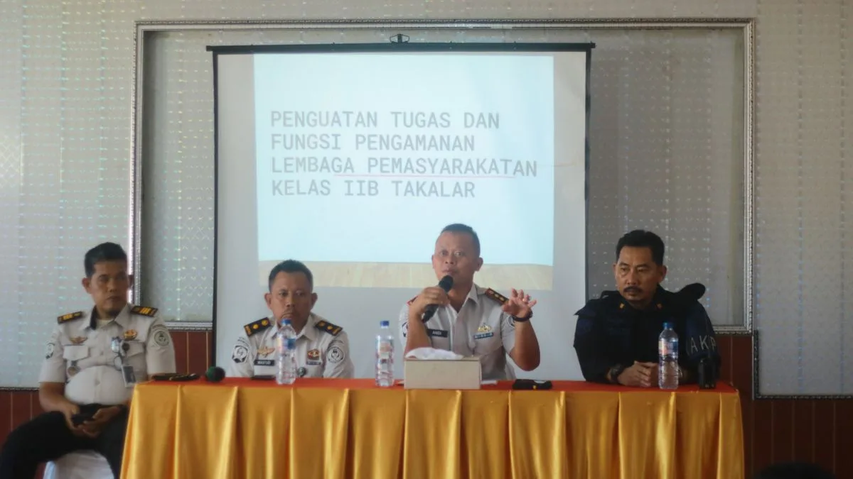 Kepala Lapas Kelas IIB Takalar Andi Gunawan memegang mikrofon saat memberikan penguatan tugas dan fungsi pengamanan di depan layar proyektor bersama jajaran pejabat struktural