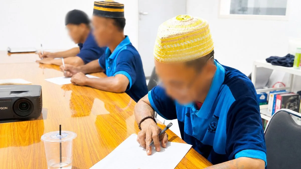 Warga Binaan Lapas Takalar Antusias Belajar Keaksaraan Fungsional, Kini Lancar Membaca dan Menulis Warga binaan Lapas Takalar memakai peci sedang serius belajar membaca dan menulis di ruang kelas keaksaraan fungsional