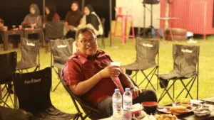 Pesona Malam Wisata Alam Paria Lau' Takalar, Sukses Pikat Hati Bupati Bupati Takalar Mohammad Firdaus Daeng Manye sedang duduk santai di kursi outdoor menikmati suasana malam di kawasan objek wisata alam Paria Lau Takalar