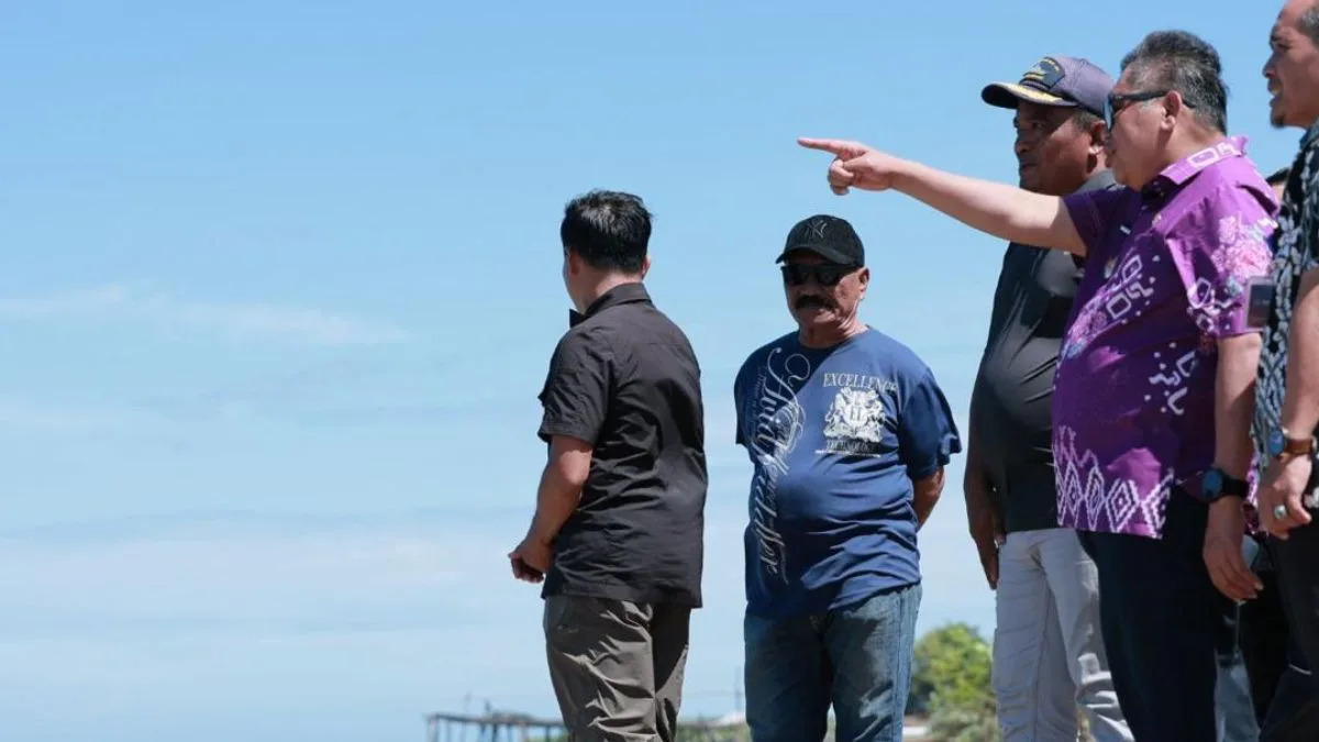 Bupati Takalar Mohammad Firdaus Daeng Manye didampingi jajaran pemerintah desa berdiri di pinggir pantai menunjuk ke arah laut lepas saat meninjau langsung kawasan Punaga Beach